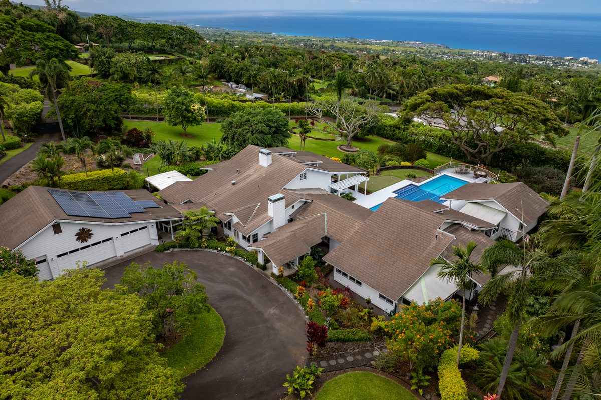 Aerial view of a multi-acre Holualoa luxury estate with pool and ocean views beyond