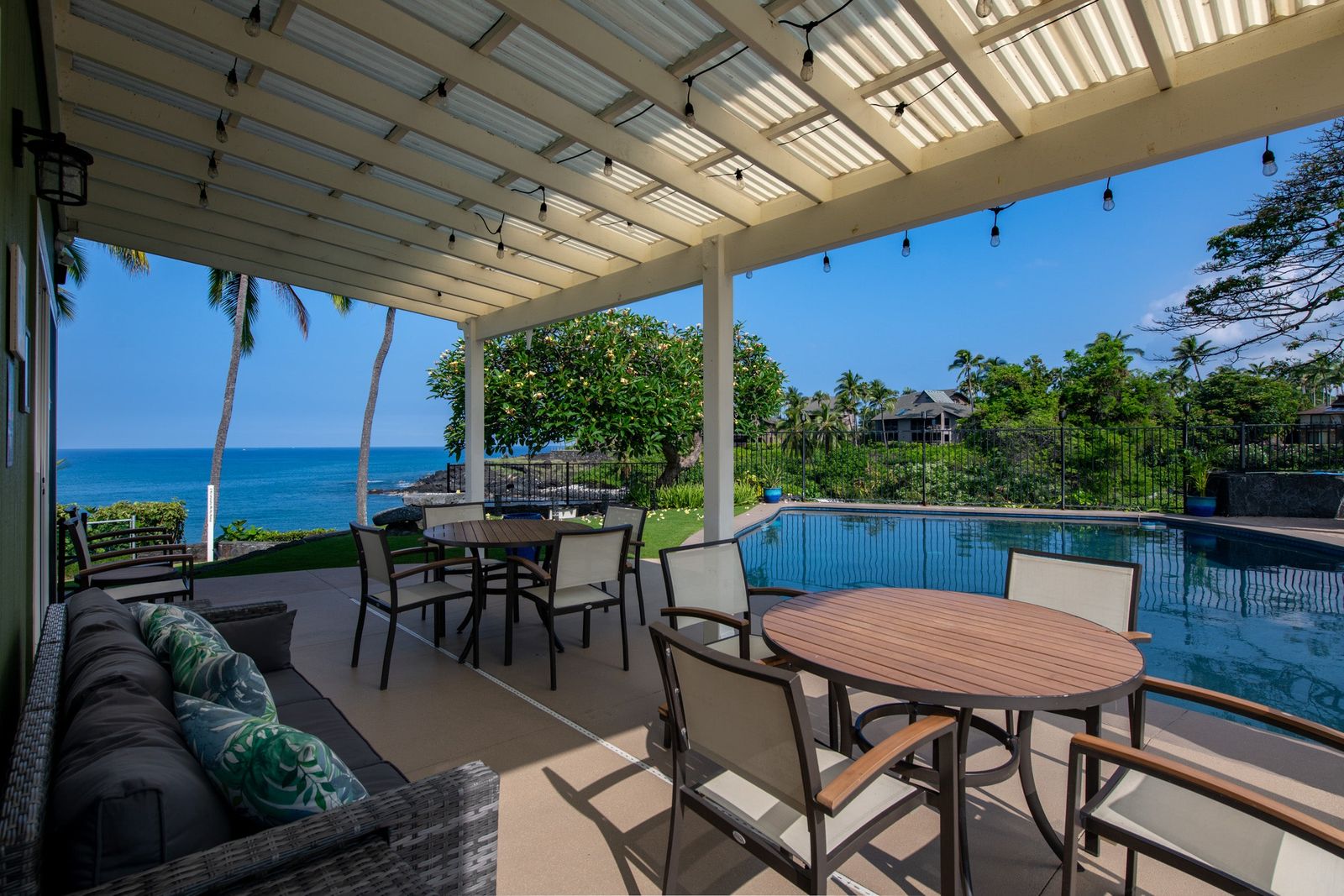 Covered lanai and pool above the ocean at Kinohi at Heʻeia, an oceanfront compound in Keauhou