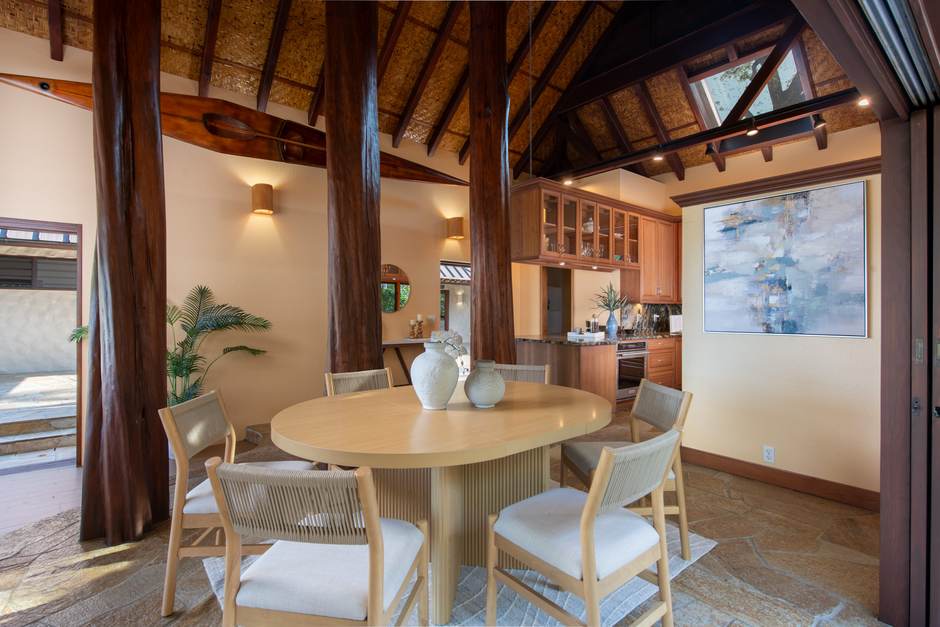 Dining beneath cathedral ceilings with the koa kitchen behind at Hale Lauleʻa