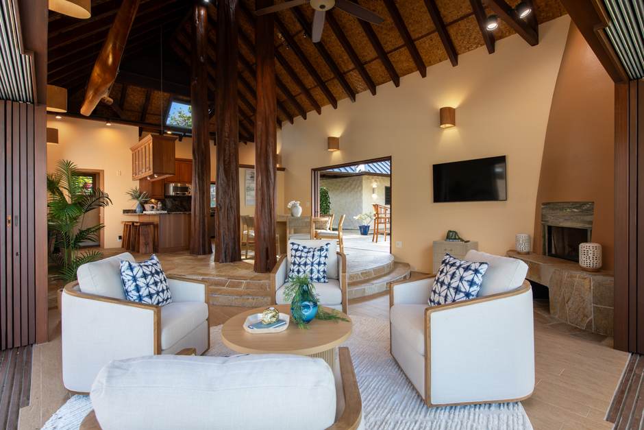 The great room at Hale Lauleʻa on ohia posts beneath a woven cathedral ceiling